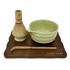 Discover the beauty of the 5 Piece Matcha Whisk Set with Wooden Display Board from Leigh Leaf, showcasing a green matcha bowl, bamboo whisk, and a wooden base for a refined tea experience.
