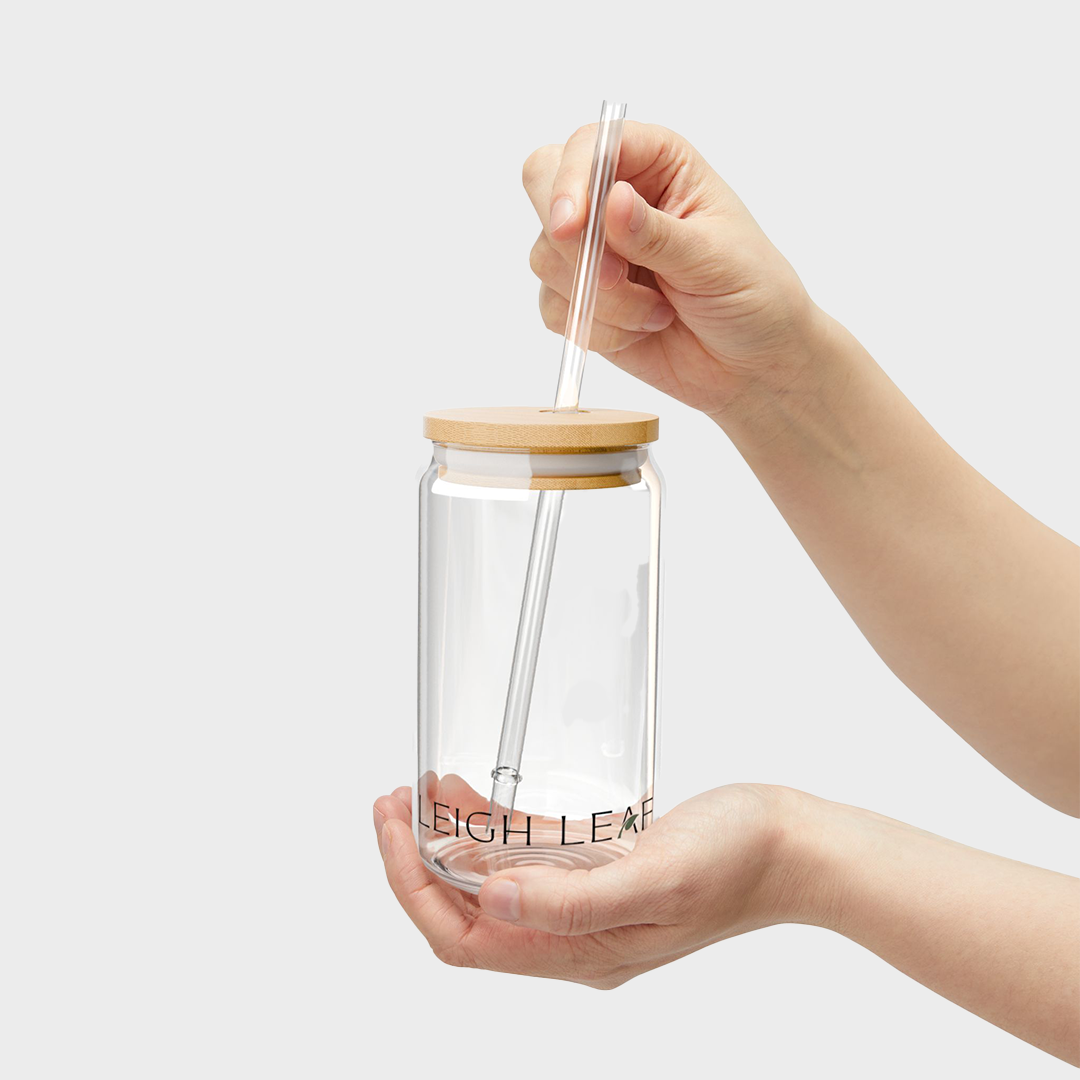 A person holding the Leigh Leaf Elegant 16oz Matcha Sipper Glass with a bamboo lid and straw, showcasing its functional design for enjoying matcha or various beverages. Perfect for matcha glass sipper enthusiasts.